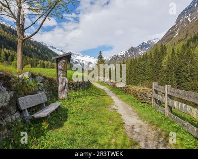 Schrein am Wegesrand mit Bank vor der Berglandschaft, Krimmler Tauern, Zillertalalpen, Kasern, Ahrntal, Bozen, Südtirol, Italien Stockfoto