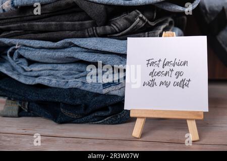 SCHNELLE MODE PASST NICHT ZU MEINEM OUTFIT Text auf Papier Zettel zu Jeans Bekleidung Sortiment Second Hand nachhaltiges Shopping. Kapsel-Minimalgarderobe. Nachhaltiger Überkonsum von Mode, bewusster Konsum, langsames Modekonzept. Abfallarmes Leben Stockfoto