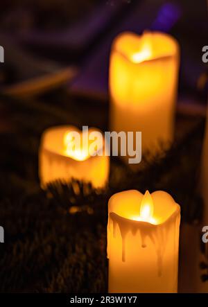 Nahaufnahme einer klassischen Kerze mit orangefarbenen Flammen Stockfoto