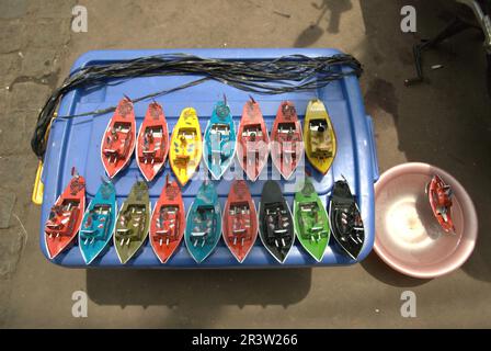 Auf einem Straßenmarkt in Jatinegara, East Jakarta, Jakarta, Indonesien, werden Boote für Kinder aus Metall verkauft. Stockfoto