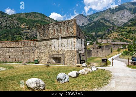 Turm und Mauern der alten Militärfestung als Berge im Hintergrund in Vinadio, Italien. Stockfoto