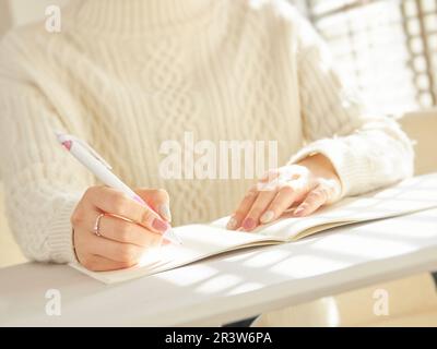 Die Hände asiatischer Frauen, die Schulaufgaben erledigen Stockfoto