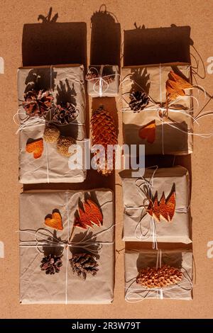 Keine verschwenderische Weihnachts-Knolling-Wohnung mit harten Schatten. Handgefertigtes Öko-Geschenk, natürliche Silvester-Jute-Dekoration, Draufsicht. Kraftpapier verpackt mit Stockfoto