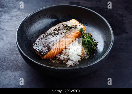 Traditionelles japanisches Teriyaki-Filet mit Lachsfisch, Koshihikari-Reis und gebratenem Spinat, serviert aus nächster Nähe in einem nordischen Desi Stockfoto