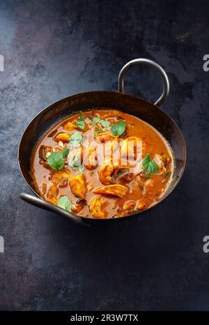 Traditionelle würzige indische Garnelen Madras Curry Rogan Josh mit Königsgarnelen, serviert aus nächster Nähe in einer Korei-Schüssel Stockfoto