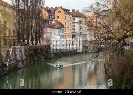 LJUBLJANA, SLOWENIEN - 7. MÄRZ 2023: Dies sind die Ufer des Flusses Ljubljanica mit den mit Steinplatten befestigten Ufern in der Mitte des Stockfoto