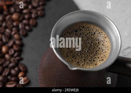 Türkischer Kaffee in Zezve auf dem Tisch, Nahaufnahme Stockfoto