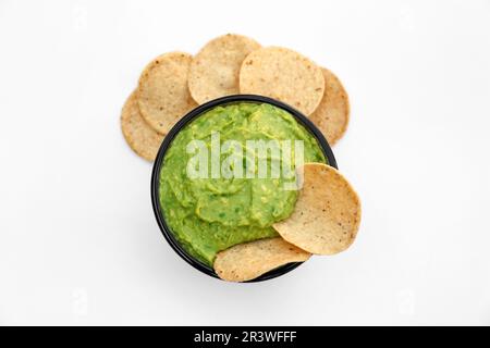 Köstliche Guacamole aus Avocados und Nachos auf weißem Hintergrund, Draufsicht Stockfoto