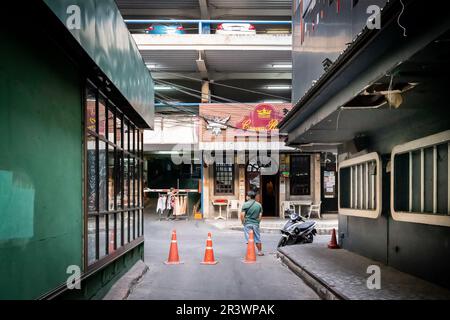 Die Aussicht auf die kleine Gasse, die Soi 1 und Soi 2 in Patpong verbindet, dem berühmten Rotlichtviertel in Bangkok. Crown Royal Pub am Ende gesehen Stockfoto