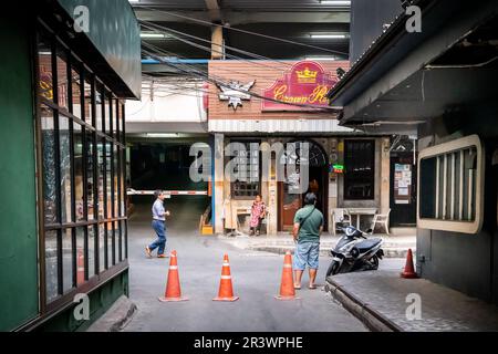 Die Aussicht auf die kleine Gasse, die Soi 1 und Soi 2 in Patpong verbindet, dem berühmten Rotlichtviertel in Bangkok. Crown Royal Pub am Ende gesehen Stockfoto