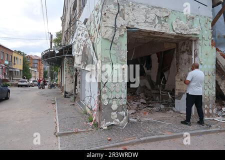 OKHTYRKA, UKRAINE - 24. MAI 2023 - Ein Mann blickt in ein Gebäude, das durch russische Bomben beschädigt wurde, Okhtyrka, Sumy Region, Nordostukraine. Stockfoto