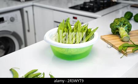 Konzept einer gesunden Ernährung und vegetarischer Lebensstil. Moderne Küche mit grünem Gemüse, romano-Helda-Bohnen, grünen Erbsen und Brokkol Stockfoto