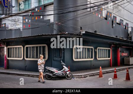 Ein Blick auf Soi 2 Patpong mit der Gogo-Bar Bada Bing. Menschen und Verkehr entlang dieser berühmten kleinen Straße im Bangkok Rotlichtviertel. Stockfoto