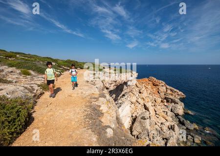 Niños andando Junto a un Acantilado, Caló des Marmols, Santanyí, Mallorca, Balearen, Spanien. Stockfoto