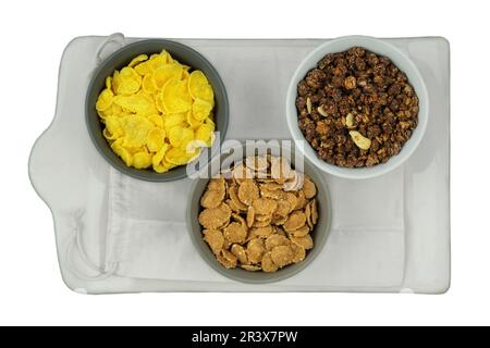 Auswahl an Frühstückszerealien und Müsli in Schüsseln isoliert auf weißem Hintergrund. Fastfood. Draufsicht. Platz für Text. Stockfoto