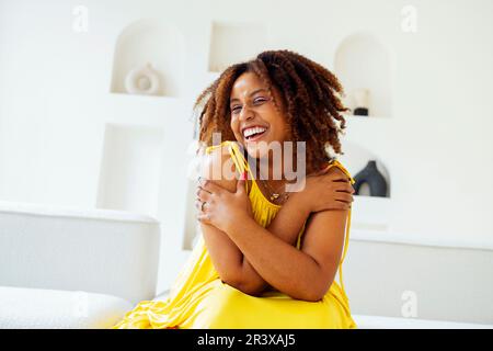 Wunderschöne, kurvige, übergroße junge afto-amerikanische Frau in einem gelben Kleid Stockfoto