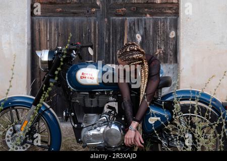 Mädchen und Royal Enfield 500 Motorrad, balearen. Stockfoto