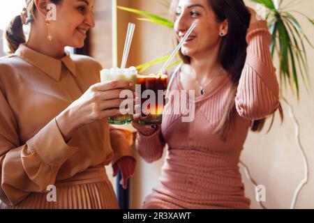 Glückliche junge Freundinnen, die eine Kaffeepause machen Stockfoto
