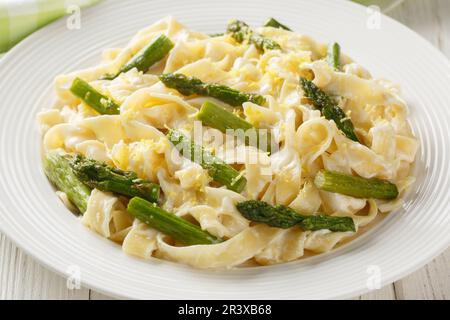 Cremige Zitronencreme Asparagus Pasta fettuccine auf dem Teller auf dem Holztisch. Horizontal Stockfoto