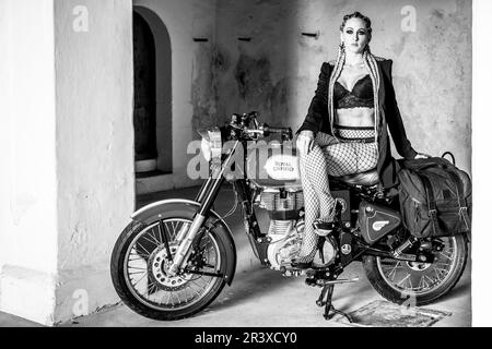 Mädchen und Royal Enfield 500 Motorrad, balearen. Stockfoto