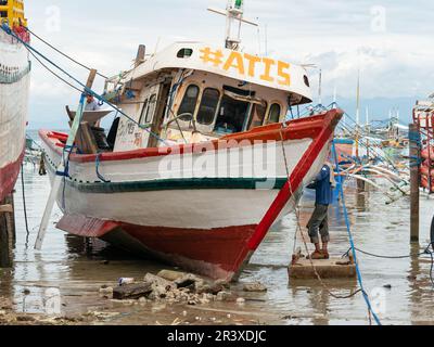 Wartung eines kleinen Fischereifahrzeugs in der Basiswerft am Strand von Tinoto, Maasim, in der Provinz Sarangani auf den Philippinen. Stockfoto