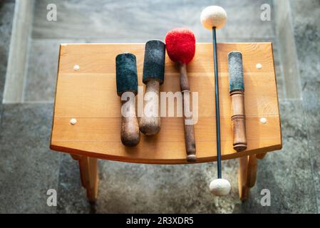 Holzstäbchen zur Schalltherapie mit Gesangsschüsseln Stockfoto