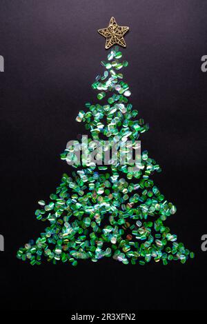 Weihnachtsbaum aus grünem Glitzer auf schwarzem Hintergrund. Neujahrskonzept mit Lametta. Flach liegend, Draufsicht Stockfoto