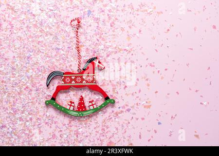 Weihnachtsbaum Holzspielzeug von Schaukelpferd auf rosa Hintergrund mit Glitzer. Flach liegend, Draufsicht von mit Kopierplatz Stockfoto