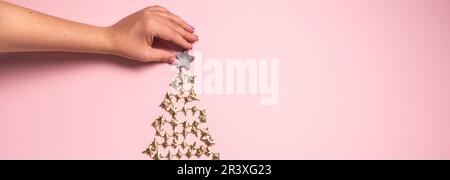 Hände schmücken goldenen Weihnachtsbaum. Blick von oben. Flach liegend Stockfoto