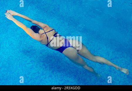 Junge Profi-Schwimmerin schwimmend im Hallenbad Stockfoto