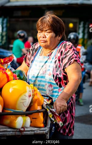 Eine thailändische Dame, die Spielzeuge von einem Wagen verkauft, fährt durch Pattaya Thailand. Stockfoto