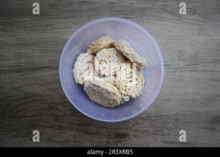 Kerupuk oder Kerupuk Warung sind traditionelle indonesische frittierte Cracker aus Stärke, gemischt mit Aromen wie Fisch, serviert in einem Kunststoffkontuin Stockfoto