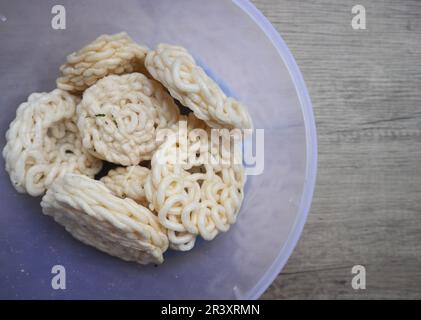 Kerupuk oder Kerupuk Warung sind traditionelle indonesische frittierte Cracker aus Stärke, gemischt mit Aromen wie Fisch, serviert in einem Kunststoffkontuin Stockfoto