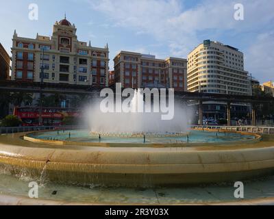 Brunnen am Plaza de La Marina mit historischen Gebäuden und das Hotel AC Málaga Palacio im Hintergrund. Stockfoto