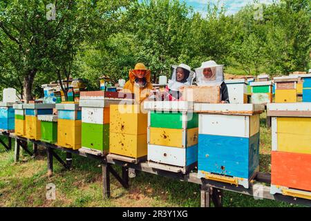 Arabische Investoren prüfen die Qualität von Honig auf einem großen Bienenzuchtbetrieb, in den sie ihr Geld investiert haben. Das Konzept des Programms Stockfoto