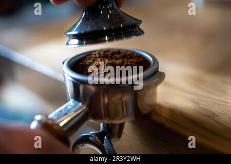 Coffee Prep, der Barista zu Hause, der Espresso mit einer Kaffeemaschinen-Extraktion und dem Trichter zubereitet, detailgenaue Aufnahmen Stockfoto