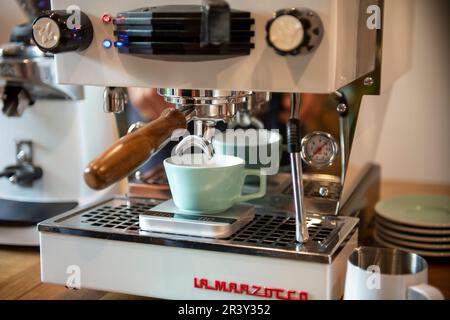 Coffee Prep, der Barista zu Hause, der Espresso mit einer Kaffeemaschinen-Extraktion und dem Trichter zubereitet, detailgenaue Aufnahmen Stockfoto