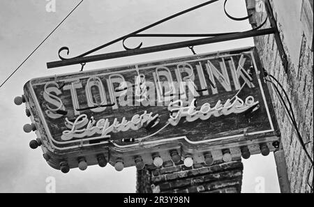 Elektrisches Schild in antikem Neon für das Stop & Drink Liquor House, amerikanisches Schwarzweiß-Schild im Stil der 1950er Jahre Stockfoto