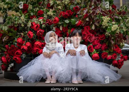 London, Großbritannien. 25. Mai 2023 Chelsea in Bloom: Junge Tänzer der Grace & Poise Academy, der ersten muslimischen Ballettschule, posieren mit den zahlreichen Blumeninstallationen zum Thema „Flowers on Film“ in Chelsea. Kredit: Guy Corbishley/Alamy Live News Stockfoto