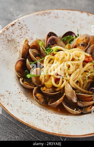 Spaghetti Pasta alle Vongole Meeresfrüchte-Pasta mit Muscheln auf Platte auf grauem Hintergrund Stockfoto