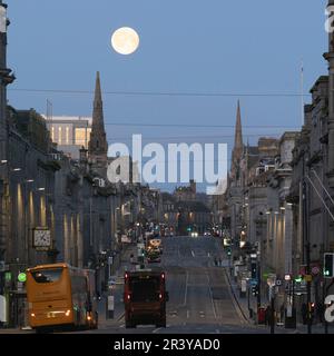 Ein Blick auf die Union Street im Stadtzentrum von Aberdeen, während der ganze (rosa) Mond im Westen kurz vor Daybreak untergeht Stockfoto