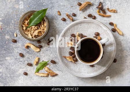 Gesundes organisches, energiegeladenes Adaptogen, trendiges Getränk. Pilzkaffee in einer Tasse mit Kaffeebohnen. Blick von oben. Stockfoto