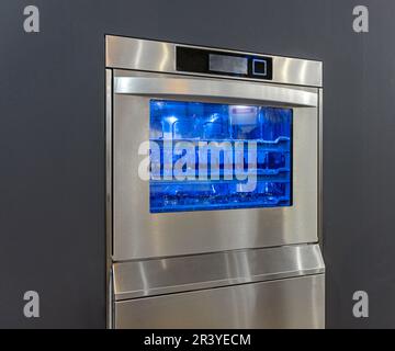 Spritzwasser in Glaswaschmaschine mit Blaulicht Reinigungsprozess Stockfoto
