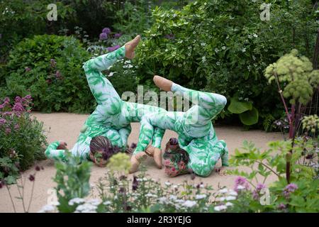 BILDER ABLEGEN. 25. Mai 2023. Die Gruppe der Öko-Aktivisten Just Stop Oil hat heute auf der Chelsea Flower Show, entworfen von Paul Hervey-Brookes, orangefarbene Farbe auf den RBC Brewin Dolphin Garden gesprüht (Bilder zeigen Künstler im Garten am Press Day am Montag Anfang dieser Woche). Pimlico, London, Großbritannien. 22. Mai 2023. Ein Paar darstellender Schlangenmenschen führt eine Interpretation durch, die den Wissenstransfer durch eine stufenweise Bewegung darstellt, wobei das Thema des Gartens aufgegriffen wird. Kredit: Maureen McLean/Alamy Live News Stockfoto