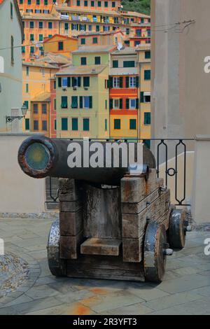 Eine alte Kanone vor dem Hintergrund farbenfroher Häuser im Ferienort Bogliasco, Ligurien. Stockfoto