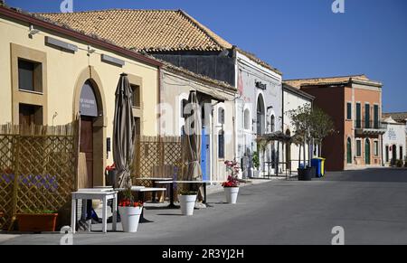 Landschaft mit malerischem Blick auf lokale Geschäfte und Gebäude auf der Via Marzamemi im sizilianischen Fischerdorf in Italien. Stockfoto