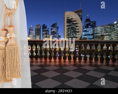 Ein Blick auf Doha, Katar von einer Terrasse (Balkon) eines hohen Gebäudes aus dem Zimmer mit wunderschönen weißen Vorhängen. Stockfoto