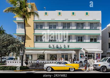 Miami, USA - 7. Dezember 2022. Blick auf das berühmte gelbe Auto vor der Art déco-Fassade des Avalon Hotels am Ocean Drive, Miami Beach Stockfoto