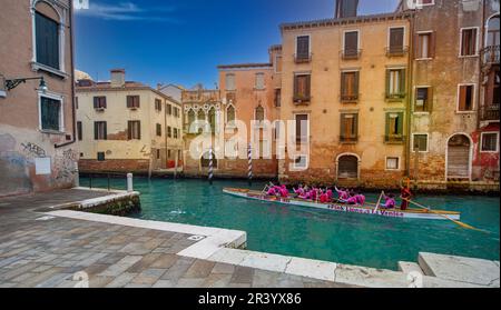 2020-Februar -24-Venedig Italien -eines der Wahrzeichen von Venedigs Nachtszene ist das Labyrinth der Kanäle. Eine Gruppe farbenfroher Kleider Stockfoto