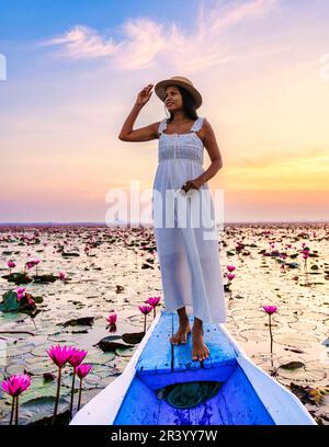 Asiatische Frauen in einem Boot am Roten Lotus Meer Kumphawapi voller rosa Blumen in Udon Thani Thailand. Stockfoto